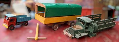 three toy trucks and a truck on a red table