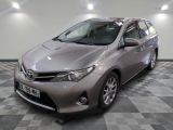 La Toyota Corolla est garée dans une grande pièce au sol carrelé.