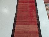 two red and black rugs sitting on a white floor next to each other