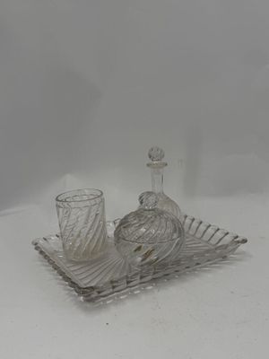 a glass tray with a bottle and a glass cup on it