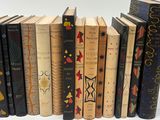 many books lined up in a row on a white surface