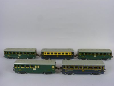 quatre wagons verts et jaunes alignés les uns à côté des autres sur une surface blanche