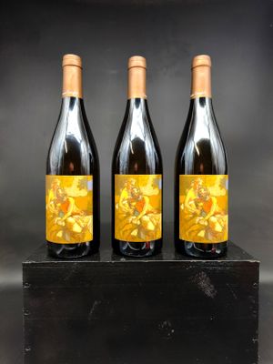 trois bouteilles de vin posées sur un bloc de bois