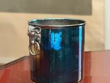 une tasse en verre bleu avec une anse en argent posée sur une table