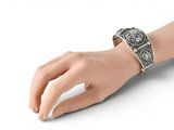 an image of a woman ' s hand with a silver bracelet