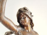 a bronze statue of a woman holding a tennis racquet