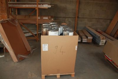 a cardboard box with cans of paint on it in a warehouse