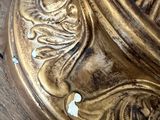 a close up of a gold lamp on a wooden table