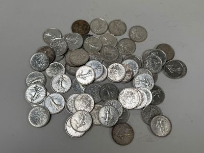 a pile of silver coins on a white surface