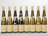 six bottles of wine lined up in a row on a white surface