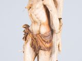 an antique carved ivory figurine of a man holding a tree branch