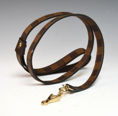 un gros plan d'une ceinture marron et noire avec une boucle dorée