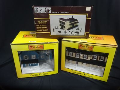 three boxed boxes of miniature model houses on a black background