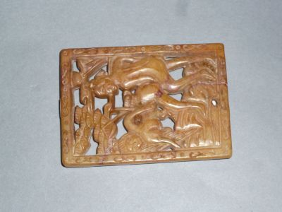 carvings of animals and birds carved into a wooden plaque on a table