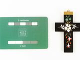 cross and identification card on a white surface with a green background