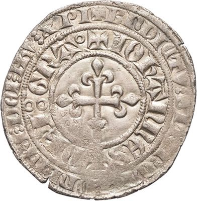 une vieille pièce d'argent ornée d'une croix