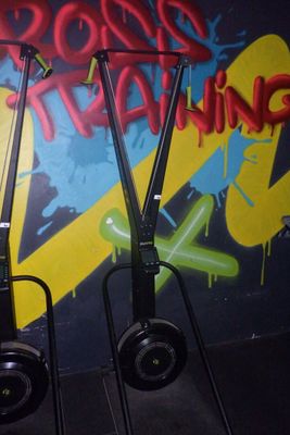 deux trottinettes électriques garées l'une à côté de l'autre devant un mur recouvert de graffitis