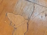 a picture of a wooden table with a butterfly on it