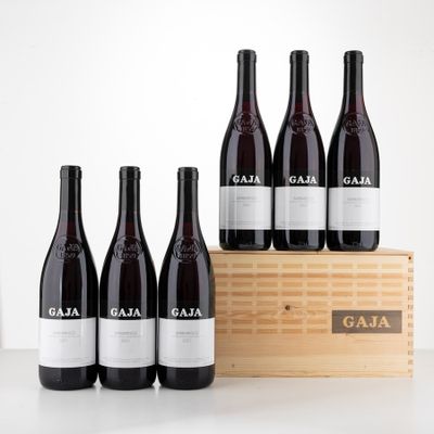 six bottles of red wine sit in front of a wooden crate