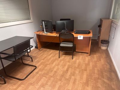 un bureau avec deux écrans d'ordinateur et une chaise dans un coin