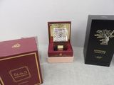 three boxes with a watch inside of them sitting on a table