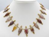 un collier orné de pierres multicolores sur un mannequin blanc