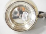 a silver tea pot with a label on it