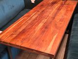 a wooden table and blue couch in the corner of a room