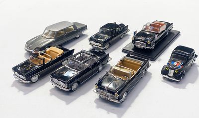 plusieurs petites voitures sont alignées sur une surface blanche