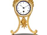 une horloge posée sur un support sur une surface blanche
