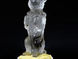 a glass figurine of a bear with a banana on a black surface