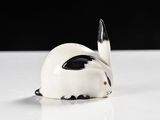 a small white rabbit figurine sitting on a table