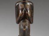 an image of a wooden statue of a man with hands clasped
