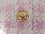 a picture of a pink and white sweater with a gold button on it