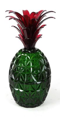 a green glass pineapple with a red flower in it