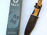 a knife that is laying next to a box of muela