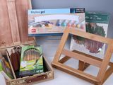 un chevalet en bois avec un kit de peinture et une boîte de feutres
