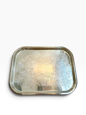 une image représentant un plateau en argent posé sur une surface blanche