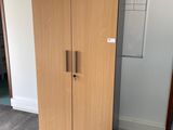 a tall wooden cabinet in the corner of a room