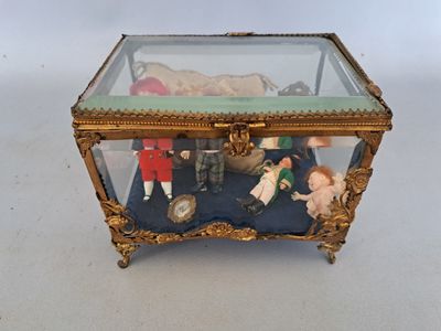 une boîte en verre posée sur une table, contenant des figurines