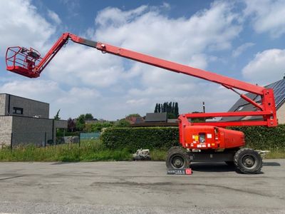 une nacelle élévatrice rouge garée au milieu d'un parking