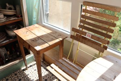 une table et une chaise en bois dans une pièce dotée d'une fenêtre