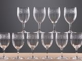six wine glasses are lined up on a wooden table