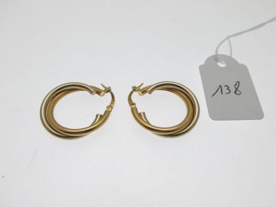 une paire de boucles d'oreilles créoles en or avec une étiquette de prix