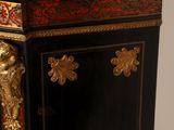 a black and gold cabinet with a clock on top of it