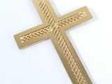 a close up of a gold cross on a white surface