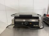 une photo d'un grill professionnel posé sur un plan de travail en acier inoxydable