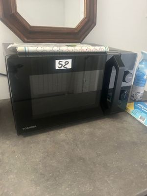 a microwave sitting on a counter next to a mirror