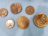 six different types of gold coins sitting on top of a blue surface