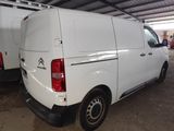 the back of a white van parked in a garage next to another van